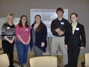 Pictured are Microbiology Club students and their advisor Dr. Martha Hutchens. They are standing in front of club member Erin Mulroney's award winning poster.